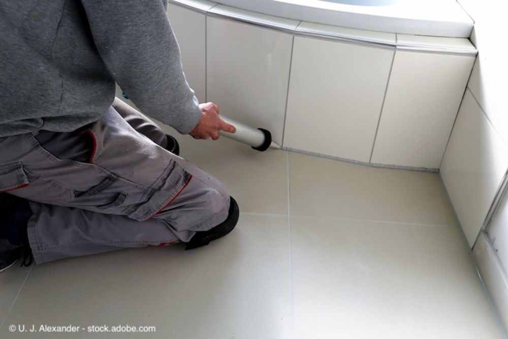 Handwerker dichtet Betonfugen mit einer Kartuschenspritze ab