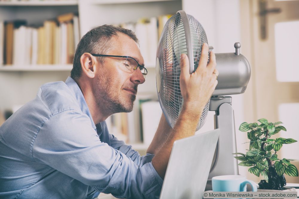 Mann-mit-einem-Ventilator-vor-dem-Gesicht-weil-er-schwitzt