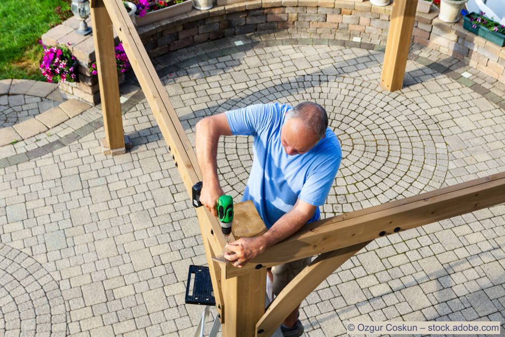 Homme-construit-une-pergola