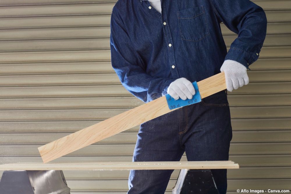 Holzoberfläche wird entlang der Maserung geschliffen zur Vorbereitung für Lasur oder Lack