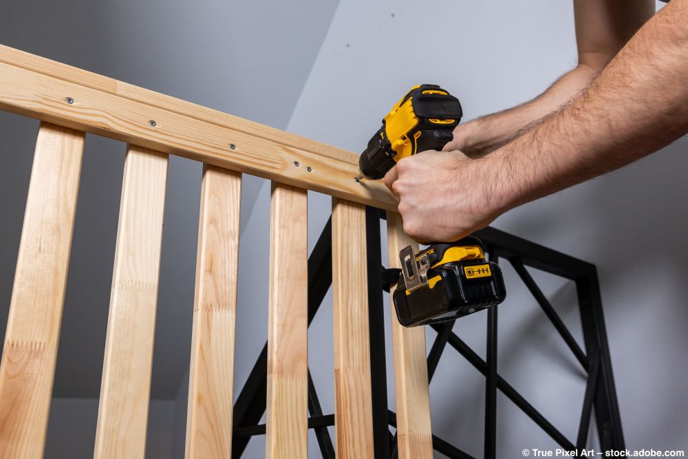 Verschrauben eines Holzrahmens zur Montage einer Absturzsicherung am Hochbett