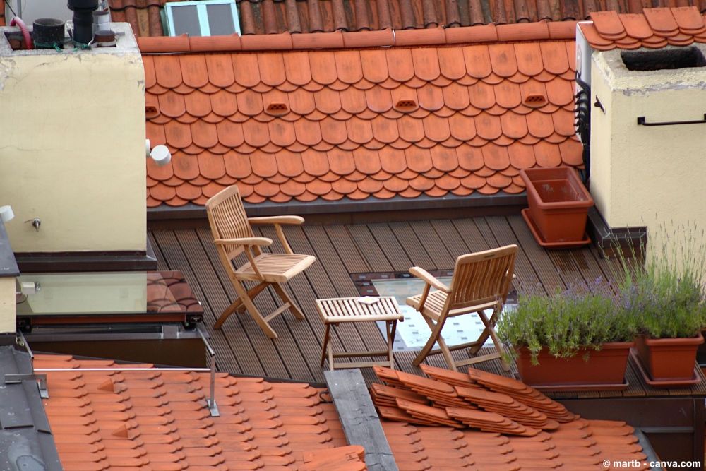 Kleine Dachterrasse mit zwei Holzstühlen und Tisch auf Holzboden