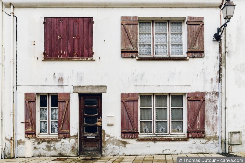 Alte Fenster von aussen mit sichtbaren Anzeichen dafür, dass die Besitzer die Fenster austauschen sollten