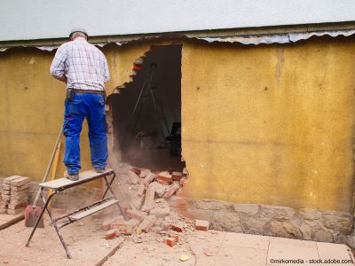 Handwerker durchbricht eine Wand