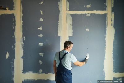 Rückansicht eines älteren Mannes bei der Renovierung eines Hauses mit Trockenbau
