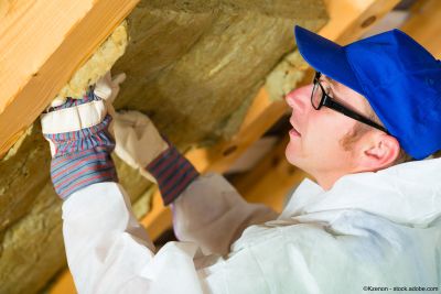 Handwerker dämmt einen Dachboden mit Dämmmaterial