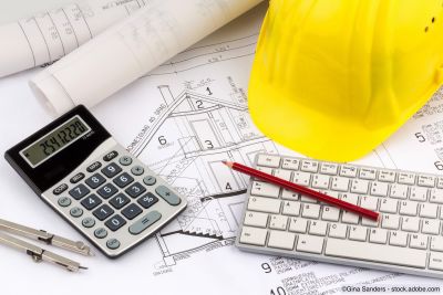 Haus- und Finanzplan mit Helm eines Bauarbeiters