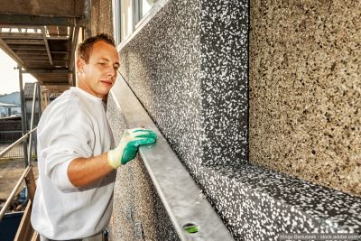Handwerker dämmt eine Fassade