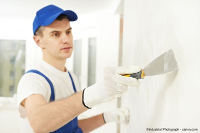 Handwerker spachtelt eine weisse Wand