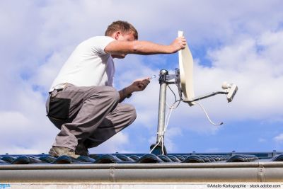 Fachmann richtet eine Satellitenschüssel aus