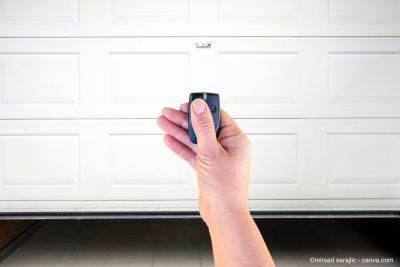 Mann öffnet Garagentor mit einer Fernbedienung