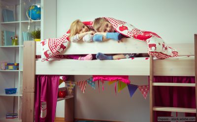 Zwei glückliche Geschwisterkinder in ihrem Hochbett