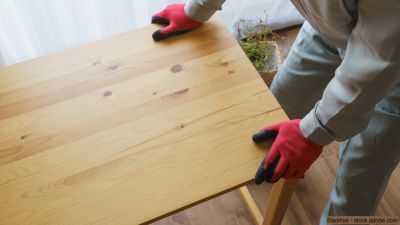 Fachmann transportiert einen Holztisch