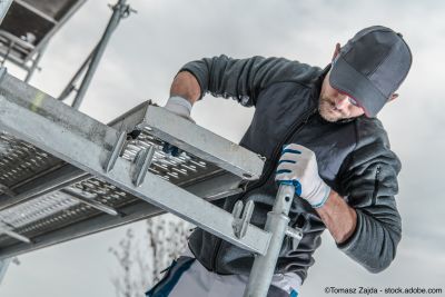 Gerüstbauer montiert Gerüstbauteile