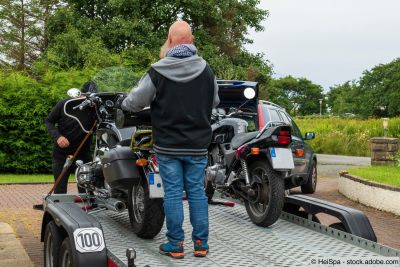 Zwei Motorräder werden auf Anhänger verladen