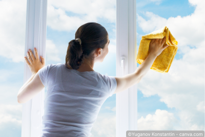 Frau reinigt Fenster