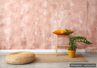 Puff und Bastteppich vor lachsrosa gefaerbter wand