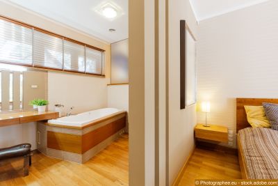 Trennwand als Raumteiler zwischen Schlafzimmer und Badezimmer mit Badewanne.
