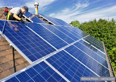 Mann installiert Photovoltaikmodule auf dem Dach