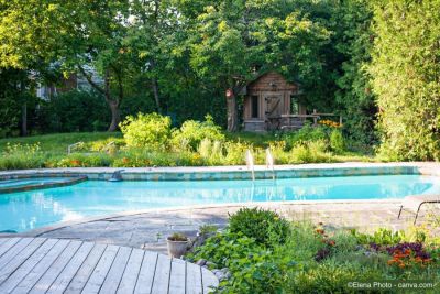 Aussenpool im Garten, umgeben von Steinplatten und Holzdeck.
