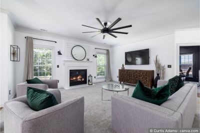 Wohnzimmer mit Teppich, Sofa und schweren Vorhängen: drei Einrichtungsstücke, die die Raumakustik verbessern