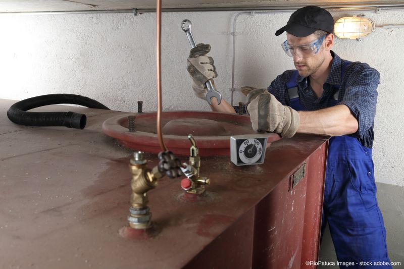 Le spécialiste en bleu de travail ouvre la citerne à mazout