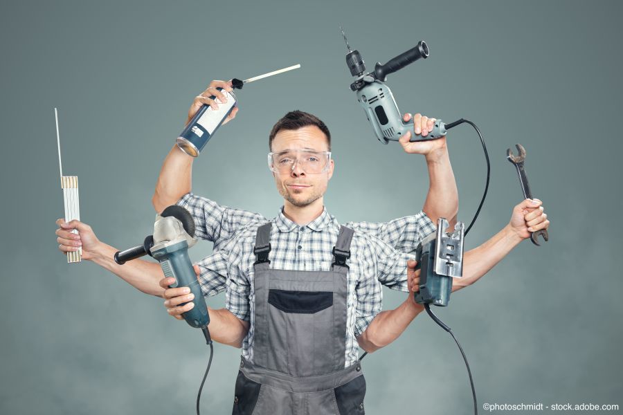Handwerker hält mehrere Werkzeuge in seinen Händen