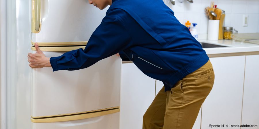 Fachmann trägt Kühlschrank