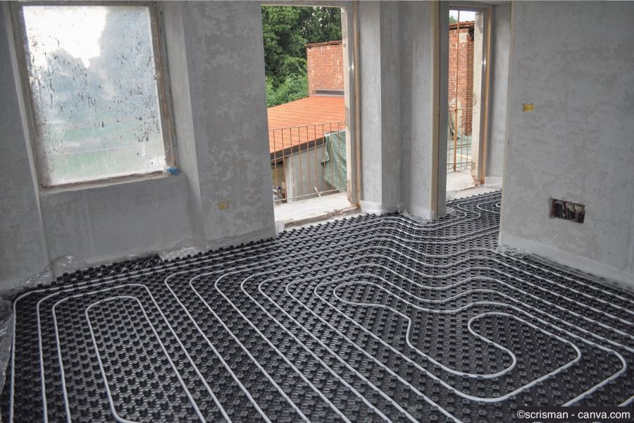 Installation einer Bodenheizung in einem Rohbauzimmer mit verlegten Heizungsrohren auf schwarzer Noppenplatte