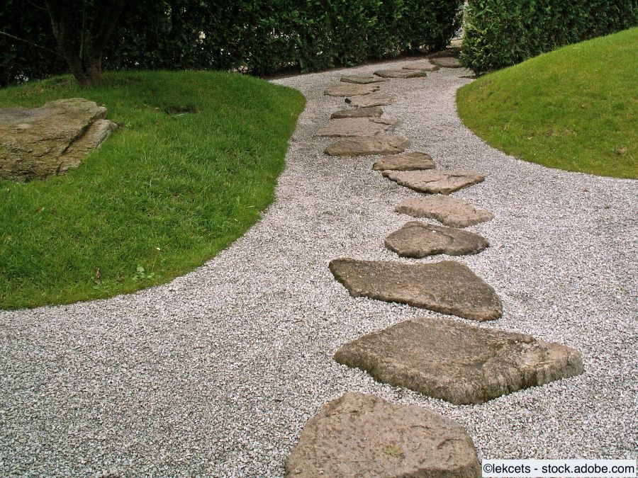 Geschwungener Kiesweg mit Trittsteinen durch eine Rasenfläche