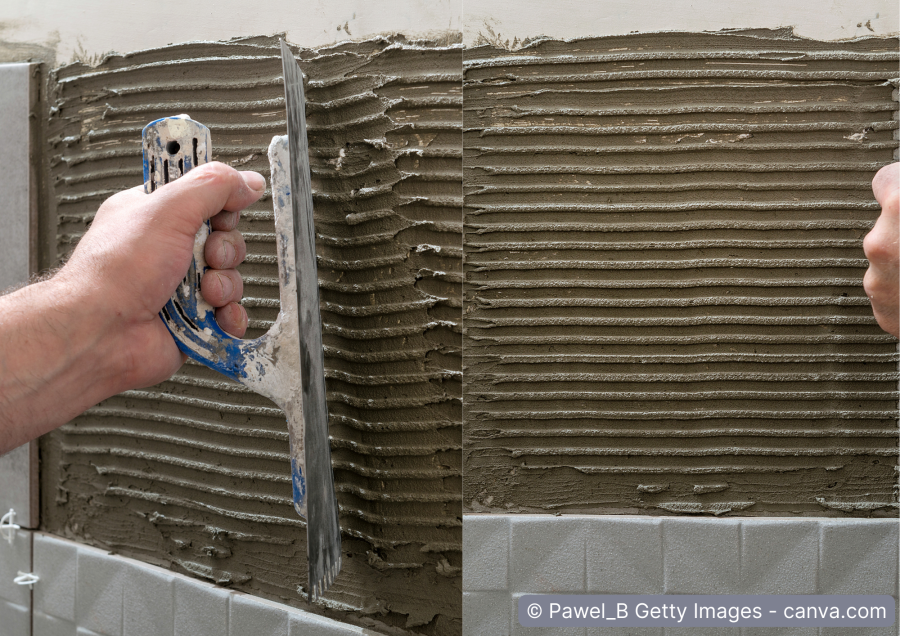 Fliesenleger traegt Fliesenkleber an Wand auf