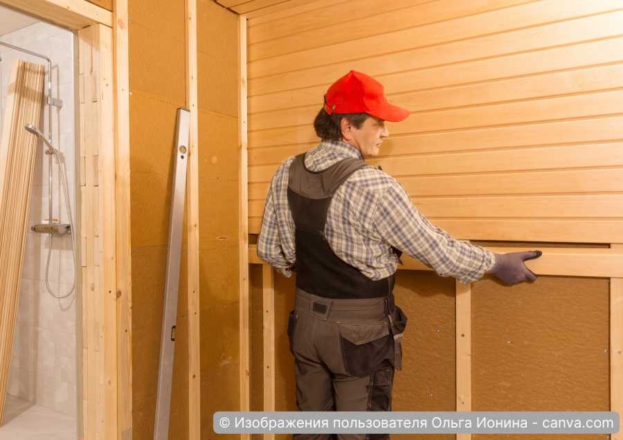Handwerker montiert Holzinnenverkleidung in Sauna