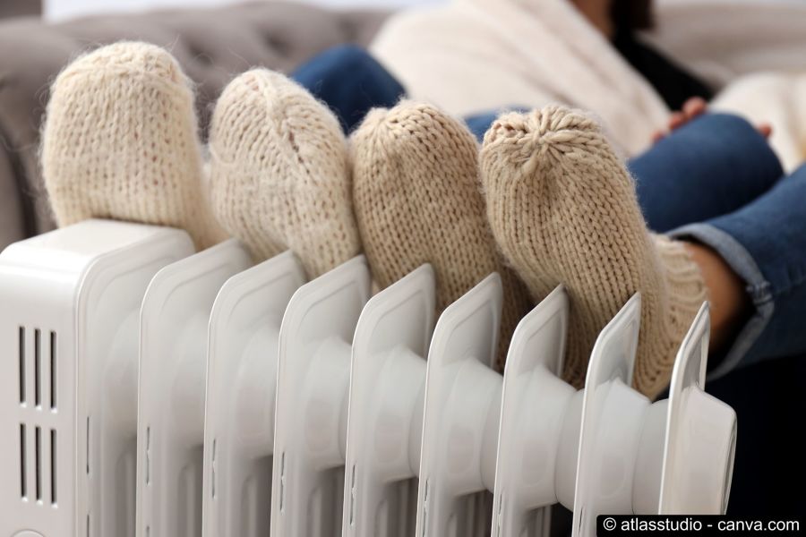 Füsse in Wollsocken liegen auf einem Heizkörper zum Aufwärmen