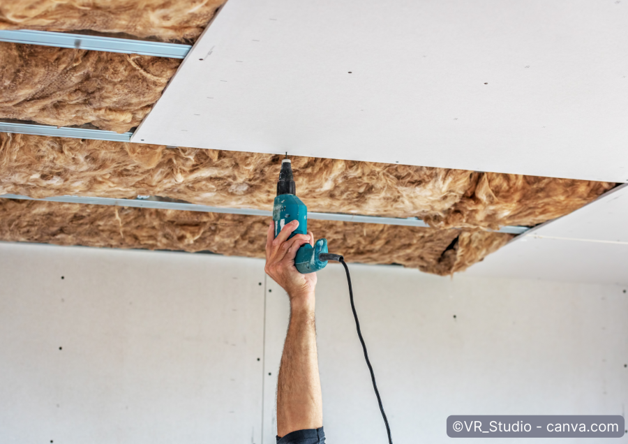 Mann befestigt Gipskartonplatten an Unterkonstruktion