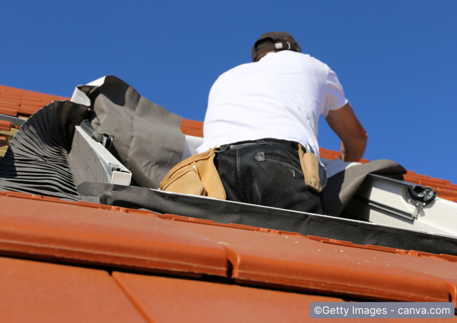 Handwerker bringt Abdichtung am Dachfenster an