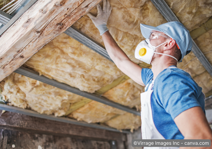 Handwerker bringt Innendaemmung am Dach-an