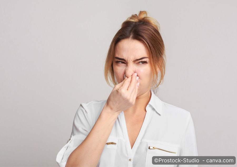 Frau hält sich Nase zu und verzieht ihr Gesicht