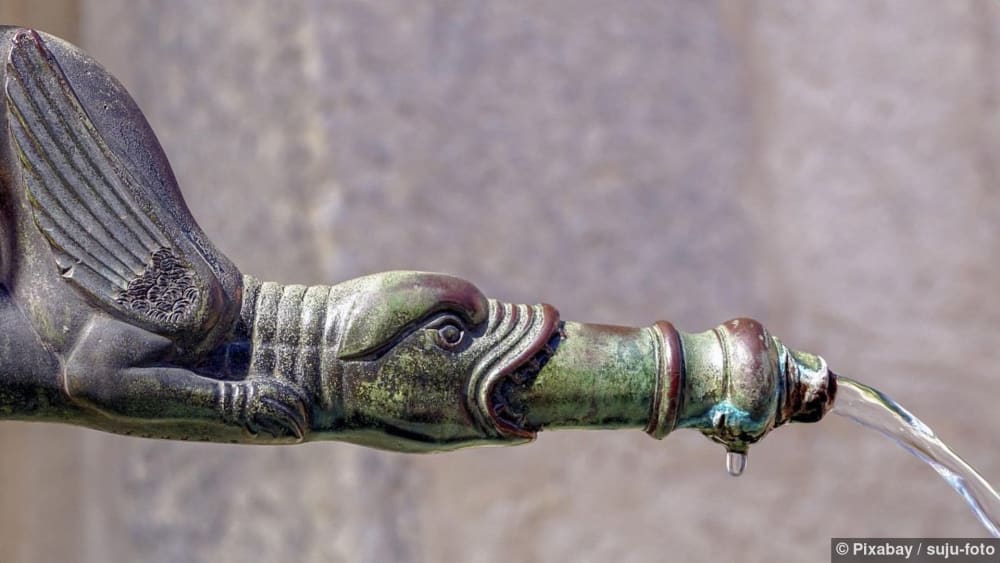 Grünspan auf einem Drachenkopf-Ausguss aus Messing, der Wasser spritzt