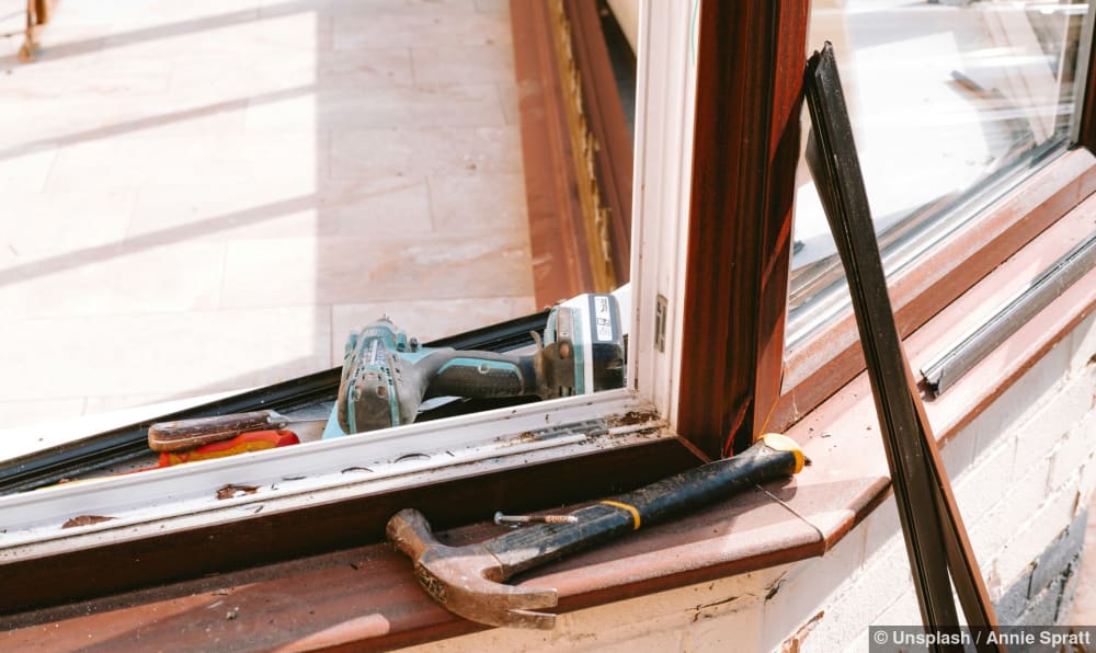 Hammer und Bohrer liegen auf einer Fensterbank während der Reparatur