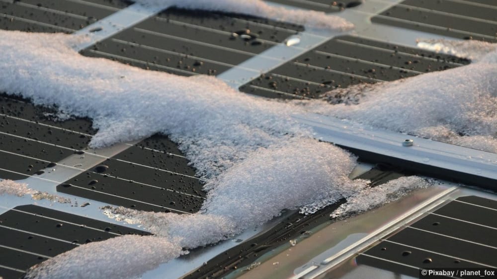 Schneebedeckte Solarmodule im Winter mit blauem Himmel