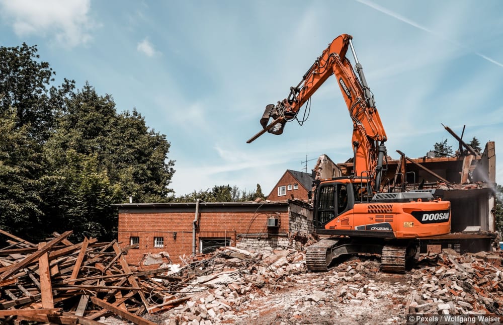 Ein Bagger reisst ein Gebäude ab