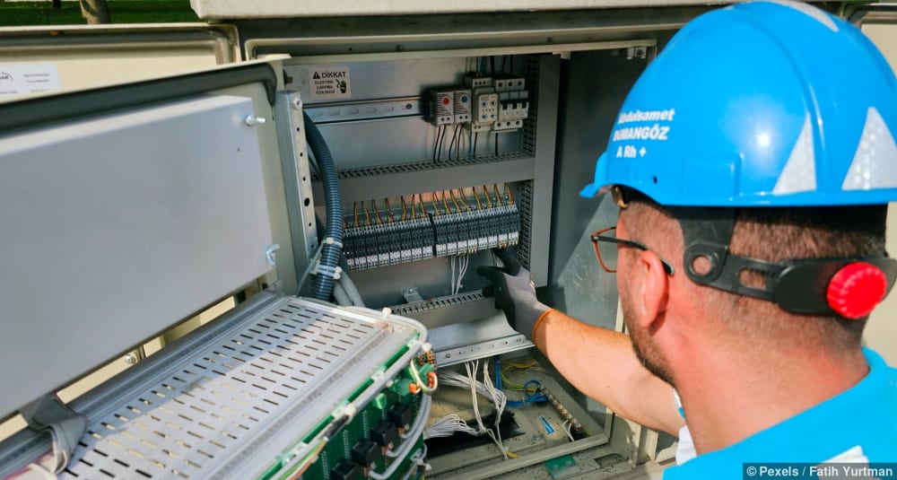 Ein Elektriker arbeitet an einem Sicherungskasten im Freien