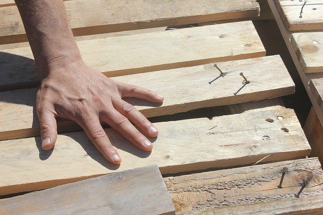 Handwerker befestigt Holzdielen
