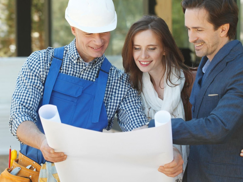 Ein Handwerker zeigt den Hausbesitzern den Bauplan