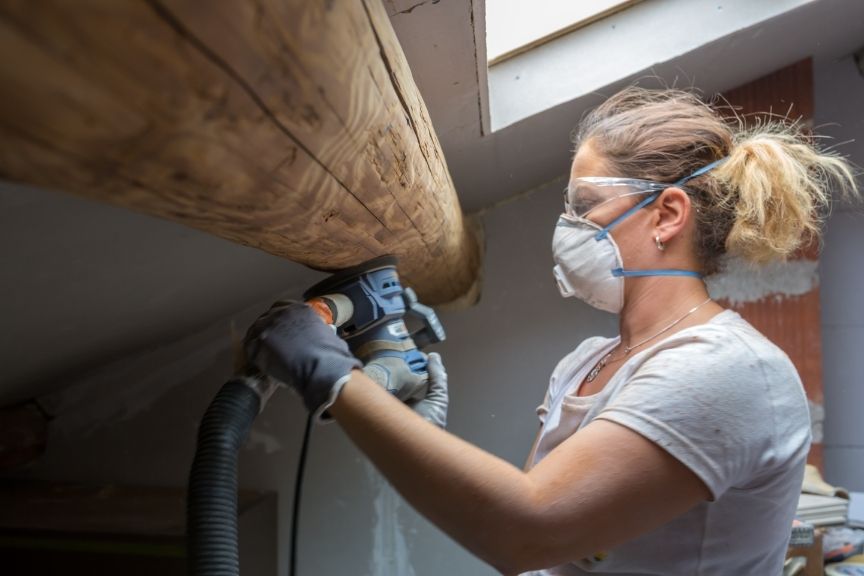 Schleifarbeiten an einem Balken für den Dachausbau