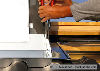 Experte für Spenglerarbeit montiert Kamineinfassung.